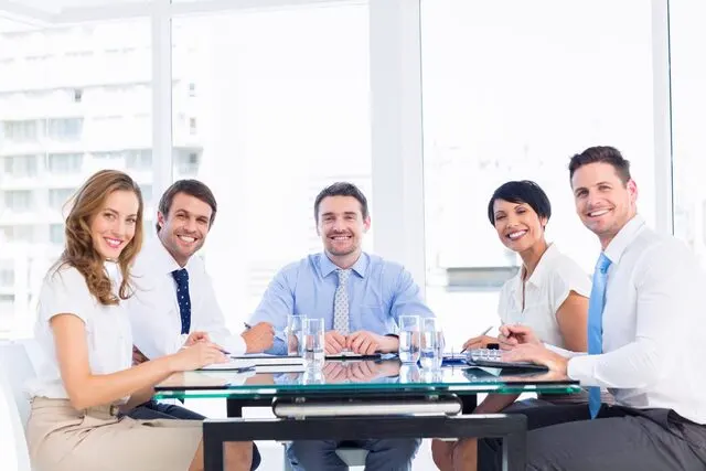 executives-sitting-around-conference-table-scaled
